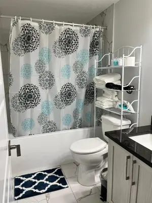 a bathroom with a toilet and a shower curtain at One bedroom private entrance suite in Edmonton
