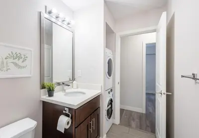 a bathroom with a sink and a washing machine at Sleek Modern Escape Suite - Comfort and Style in the City in Vancouver