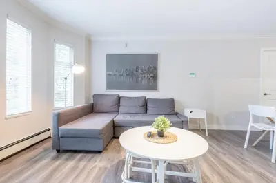 a living room with a couch and a table at Sleek Modern Escape Suite - Comfort and Style in the City in Vancouver