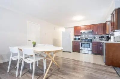 a kitchen with a white table and white chairs at Sleek Modern Escape Suite - Comfort and Style in the City in Vancouver