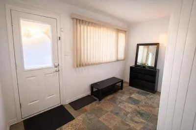 a room with a door and a mirror and a dresser at Great Northern Escapes - The Managers House in Yellowknife
