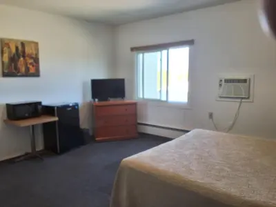 a bedroom with a bed and a dresser and a window at Wildwood Hotel in Wildwood