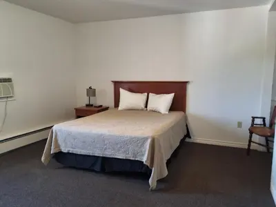 a bedroom with a bed and a table and a chair at Wildwood Hotel in Wildwood