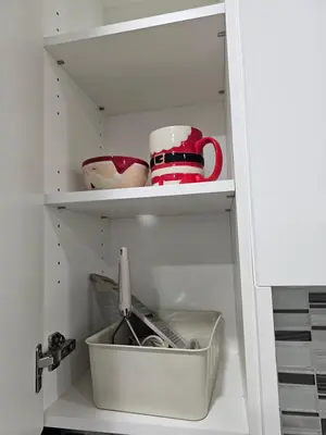 a cupboard with some dishes and cups in it at Non Smoking- Stylish Basement Suite Near Airport, Trails & Dining in Edmonton