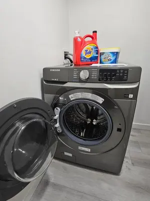 a washing machine sitting next to a washer at Non Smoking- Stylish Basement Suite Near Airport, Trails & Dining in Edmonton
