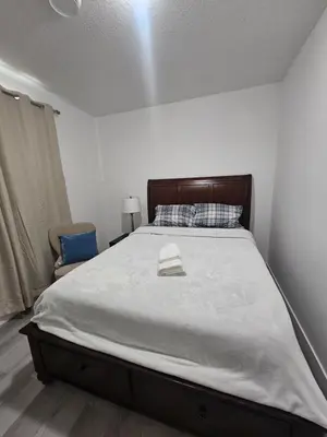 a bedroom with a large bed with a hat on it at Non Smoking- Stylish Basement Suite Near Airport, Trails & Dining in Edmonton