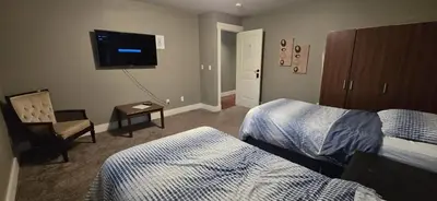 a hotel room with two beds and a flat screen tv at Rocky View Bed & Breakfast in Calgary