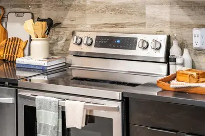 a kitchen with a stove and a counter top at NEW Restful Retreat with Hot Tub, King Bed, AC, Garage, Near WEM in Edmonton