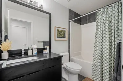 a bathroom with a sink and a toilet and a shower at NEW Restful Retreat with Hot Tub, King Bed, AC, Garage, Near WEM in Edmonton