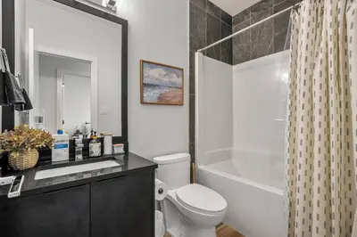 a bathroom with a toilet and a sink and a shower at NEW Restful Retreat with Hot Tub, King Bed, AC, Garage, Near WEM in Edmonton