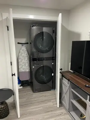 a laundry room with two washer and dryer at The Willow Nest lower suite-2 Rooms in Calgary