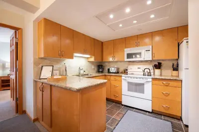 a kitchen with wooden cabinets and white appliances at Marquise 610 by Outpost Whistler in Whistler