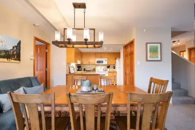 a dining room and kitchen with a wooden table and chairs at Marquise 610 by Outpost Whistler in Whistler