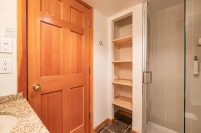 a bathroom with a shower and a wooden door at Marquise 610 by Outpost Whistler in Whistler
