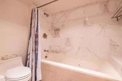 a bathroom with a tub and a toilet and a sink at Marquise 610 by Outpost Whistler in Whistler