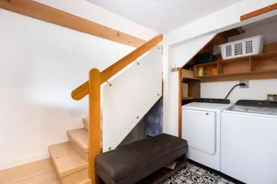 a tiny house with a staircase and a washer and dryer at Ocean Vista In the Woods on Saltspring Island in Salt Spring Island