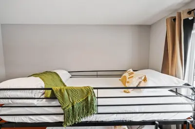 a bed with a metal frame in a bedroom at Cowboy Chalet SE|AC|Games|King Bed|20 min to DT in Calgary