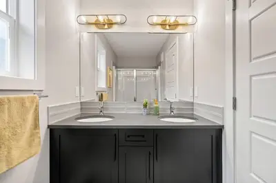 a bathroom with two sinks and a large mirror at Cowboy Chalet SE|AC|Games|King Bed|20 min to DT in Calgary
