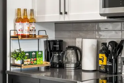 a kitchen counter with bottles of alcohol on a shelf at Cowboy Chalet SE|AC|Games|King Bed|20 min to DT in Calgary
