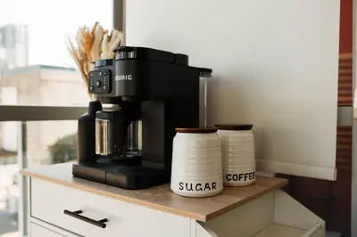 a coffee maker on a counter with two cups at City Views Walk to Calgary Tower and Stampede in Calgary