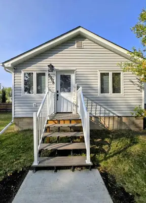 a house with a staircase in front of a house at The Oasis in Stettler! in Stettler