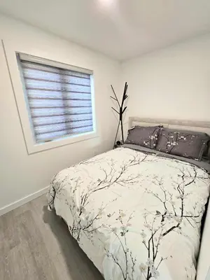 a bedroom with a bed and a window at The Oasis in Stettler! in Stettler