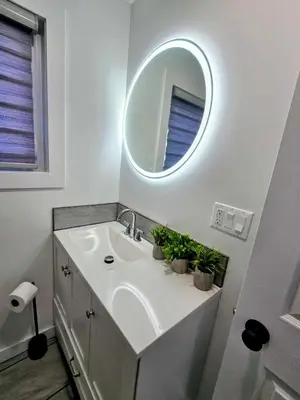 a bathroom with a sink with a mirror and potted plants at The Oasis in Stettler! in Stettler
