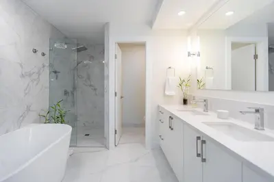 a white bathroom with two sinks and a shower at High Tide Suite - New Bright Oceanfront Escape with Spa-like Bath in Nanoose Bay