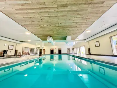 an indoor swimming pool with blue water at High Tide Suite - New Bright Oceanfront Escape with Spa-like Bath in Nanoose Bay
