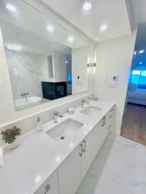 a white bathroom with two sinks and a large mirror at High Tide Suite - New Bright Oceanfront Escape with Spa-like Bath in Nanoose Bay