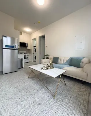 a living room with a couch and a refrigerator at South surrey Secondary Suite with Kitchen in Surrey
