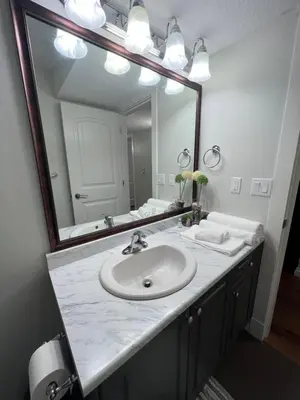 a bathroom with a sink and a large mirror at Beautiful Entire 2 Bedroom Suite in Nanaimo