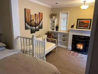 a bedroom with a crib and a fireplace in a room at Suit near Grousmountain in North Vancouver