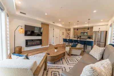 a living room with a couch and a table at Rooftop Hot Tubs 2Bd 2Ba Corner Unit w Views in Canmore