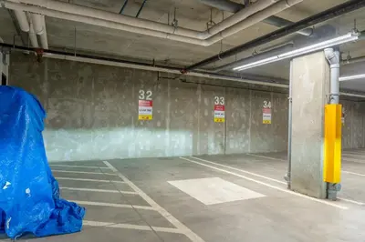an empty parking garage with a blue tarp on the wall at Rooftop Hot Tubs 2Bd 2Ba Corner Unit w Views in Canmore