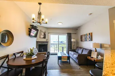 a living room with a couch and a table at Cozy King Condo Mountain Views, Resort Perk and BBQ in Canmore