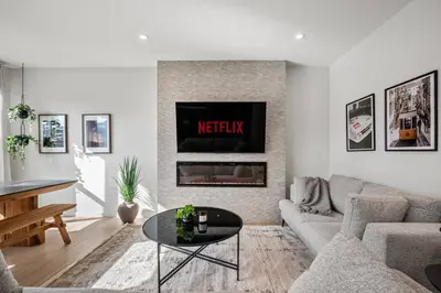 a living room with a couch and a fireplace at Luxury 7 Bedroom House with Karaoke Sound System and 100 Inch Projector in Calgary
