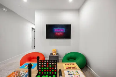 a room with two chairs and a tv on a wall at Luxury 7 Bedroom House with Karaoke Sound System and 100 Inch Projector in Calgary