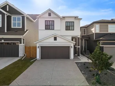 a large house with a garage in the driveway at Luxury 7 Bedroom House with Karaoke Sound System and 100 Inch Projector in Calgary