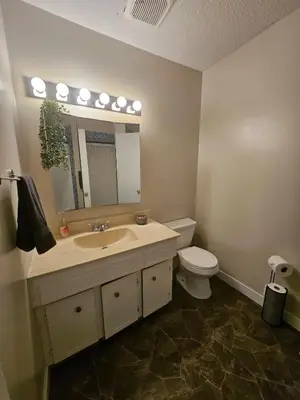 a bathroom with a sink and a toilet and a mirror at The Onyx Suite In Inglewood Minutes To DT in Calgary