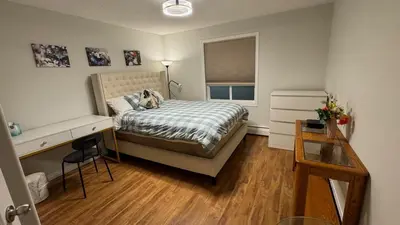 a bedroom with a dog laying on a bed at Main Floor Condo Fully Independent 1 Bed 1 Bath in Edmonton