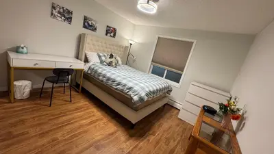 a small bedroom with a bed and a desk and a desk at Main Floor Condo Fully Independent 1 Bed 1 Bath in Edmonton