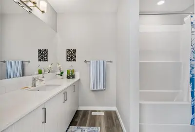 a white bathroom with a sink and a shower at Cozy 3-Bedroom Family Retreat Home in Rangeview in Calgary