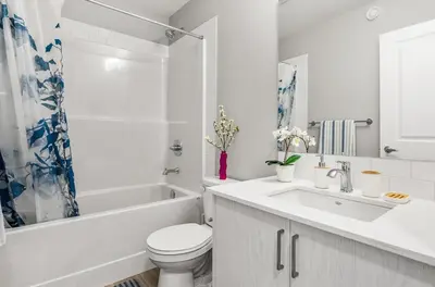 a white bathroom with a toilet and a sink at Cozy 3-Bedroom Family Retreat Home in Rangeview in Calgary