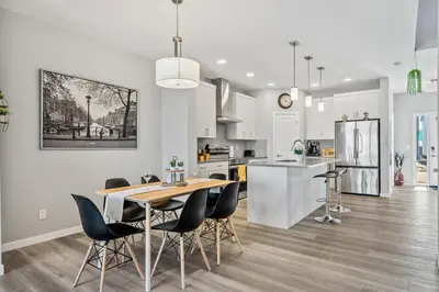a kitchen and dining room with a table and chairs at Cozy 3-Bedroom Family Retreat Home in Rangeview in Calgary