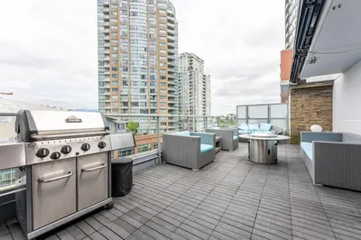 a rooftop patio with a grill and furniture on a building at The Vancouver Penthouse, 2-Level, Patios, Hot Tub in Vancouver