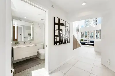 a bathroom with a toilet and a sink and a mirror at The Vancouver Penthouse, 2-Level, Patios, Hot Tub in Vancouver