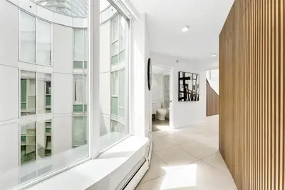 a hallway with white walls and large windows at The Vancouver Penthouse, 2-Level, Patios, Hot Tub in Vancouver