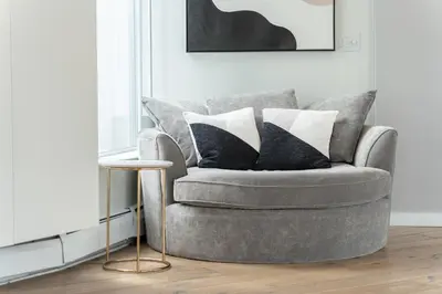 a grey chair with pillows on it in a living room at The Vancouver Penthouse, 2-Level, Patios, Hot Tub in Vancouver