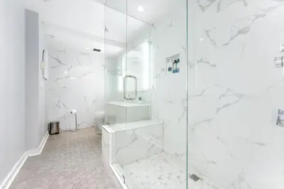 a white bathroom with a shower and a sink at The Vancouver Penthouse, 2-Level, Patios, Hot Tub in Vancouver